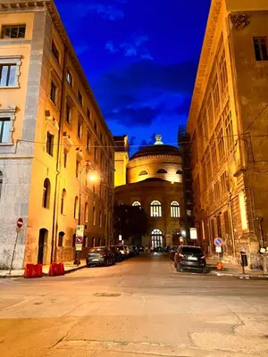 a large building with cars parked in a parking lot at Donizetti 19 in Palermo