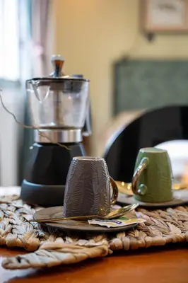 a table with a coffee maker and cups on it at Le Tartarughe di Ro' Casavacanze in Mondello