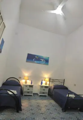 a bedroom with two beds and two night stands at CASA DEI SOGNI in Palermo