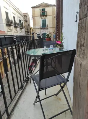 a table and a chair sitting on a balcony at CASA DEI SOGNI in Palermo