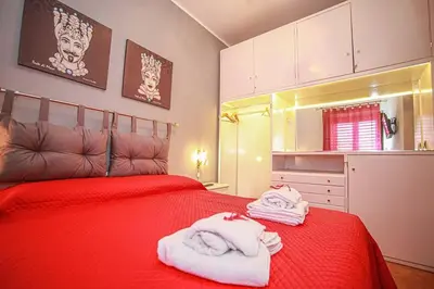 a bedroom with a red bed with towels on it at Appartamento con terrazza al centro storico. in Palermo