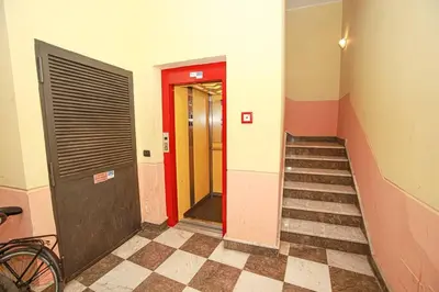a hallway with a staircase and a red door at Appartamento con terrazza al centro storico. in Palermo