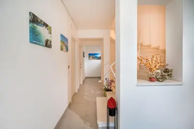 a hallway with stairs and paintings on the walls at Villa Maria con piscina e vista mare in Castellammare del Golfo