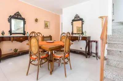 a dining room with a wooden table and chairs at Independent Villa Located a few Minutes Walk From the Beach in Quiet Area in Palermo