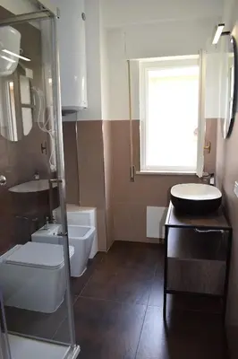 a bathroom with a sink and a toilet and a window at Independent Villa Located a few Minutes Walk From the Beach in Quiet Area in Palermo