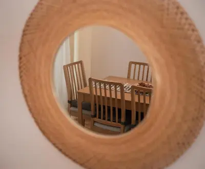 a table and chairs are seen through a circular mirror at Itiseasy Palermo 1 e 2 Private Apartments in Palermo