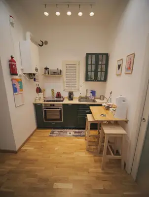 a kitchen with green cabinets and a wooden table at Itiseasy Palermo 1 e 2 Private Apartments in Palermo