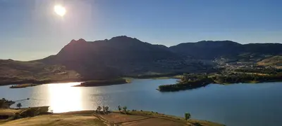 a view of a lake with a mountain in the background at Flyhouse PARCHEGGIO AUTO BICI GRATUITO in Piana degli Albanesi