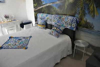 a bedroom with a bed with pillows and a chair at MARINA BAY in Terrasini