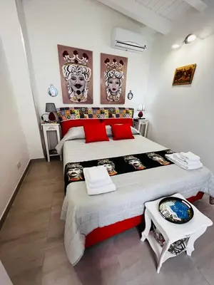 a bedroom with a large bed with red pillows at MARINA BAY in Terrasini