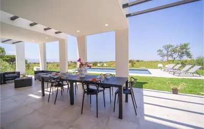 a dining room with a table and chairs and a pool at 5 Bedroom Nice Home In Trappeto in Trappeto