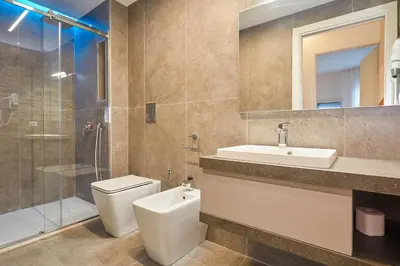 a bathroom with a toilet and a sink and a shower at Porta del Golfo Apartments & Suites in Castellammare del Golfo