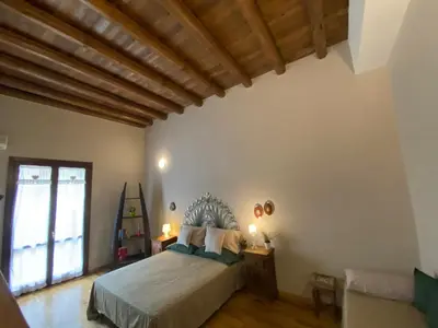 a bedroom with a large bed and a wooden ceiling at Casa Vetriera in Palermo