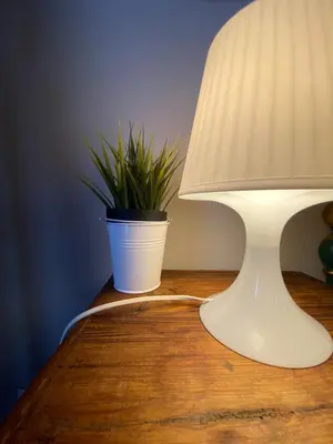 a white lamp sitting on a table with a plant at Casa Vetriera in Palermo