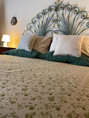 a bed with a metal headboard and pillows on it at Casa Vetriera in Palermo