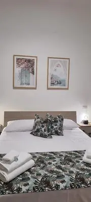 a bed with two pillows and a blanket on it at Christian Guest House in Terrasini