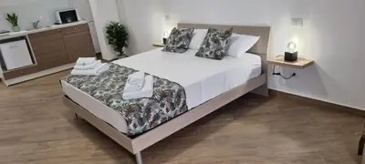 a bedroom with a large bed with white sheets and pillows at Christian Guest House in Terrasini