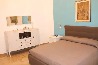 a bedroom with a bed and a dresser with a mirror at A casa di Enza B&B in Palermo