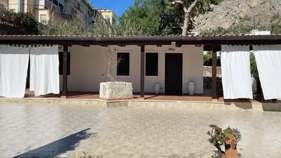 a house with white curtains on a patio at Campofelice Casa vacanza in Palermo