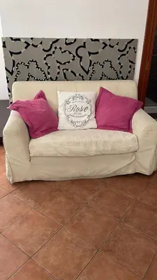 a couch with three pillows on top of it at Campofelice Casa vacanza in Palermo