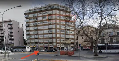 a tall building with an orange sign in front of it at Sostegno d'amore in Palermo