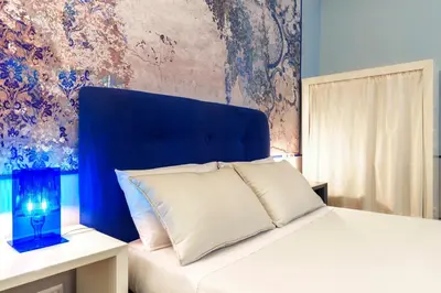 a bedroom with a bed with a blue headboard at CELSO 14 in Palermo