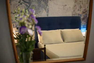 a reflection of a couch in a mirror with a vase of flowers at CELSO 14 in Palermo