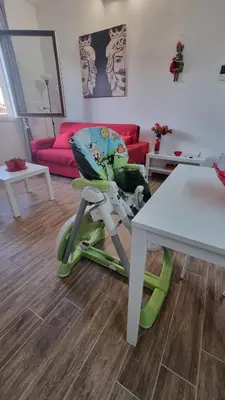 a childs high chair in a living room with a table at Balsamotto - Appartamento e parcheggio in Palermo