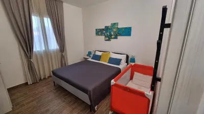 a small bedroom with a bed and a cross on the wall at Balsamotto - Appartamento e parcheggio in Palermo