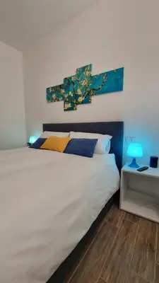 a bedroom with a large white bed with blue lamps at Balsamotto - Appartamento e parcheggio in Palermo