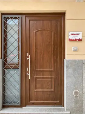 a wooden door on a building with a sign on it at Momenti e Monumenti in Palermo