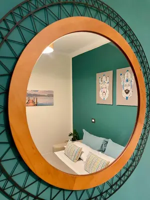 a circular mirror in a bedroom with a bed at Essenze di Sicilia Appartamento Cavour in centro in Palermo