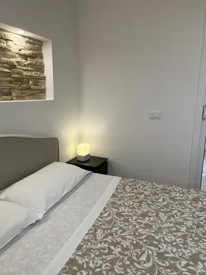 a bedroom with a bed and a side table with a lamp at Home holiday Kalanto in Castellammare del Golfo
