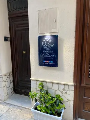 a sign on the side of a building with a plant at Home holiday Kalanto in Castellammare del Golfo