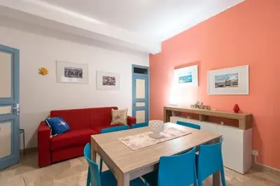 a living room with a table and a red couch at Home holiday Kalanto in Castellammare del Golfo