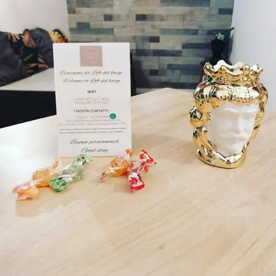 a table with a invitation and a diploma and a gold crown at Casa vacanze Loft del Borgo in Palermo