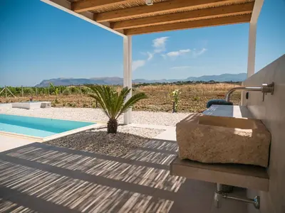 a bathroom with a sink and a swimming pool at VILLA DELLA QUBBAH with pool in Alcamo