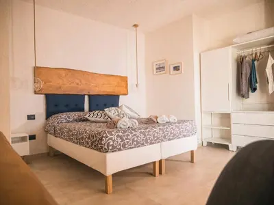 a bedroom with a bed with a wooden headboard at VILLA DELLA QUBBAH with pool in Alcamo
