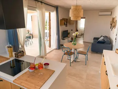 a kitchen and living room with a table and chairs at VILLA DELLA QUBBAH with pool in Alcamo