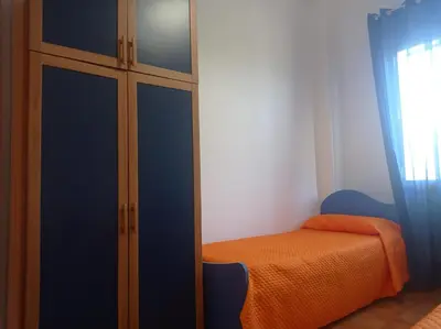 a bedroom with an orange bed and a glass cabinet at Villa Andrea in Scopello