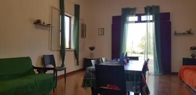 a living room with a green couch and a table at Villa Andrea in Scopello