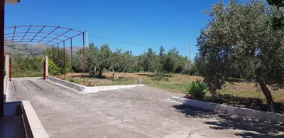 an empty parking lot with a gate and a tree at Villa Andrea in Scopello