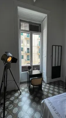 a room with a bed and a window with a table at DonnaFrancaFlorio in Palermo