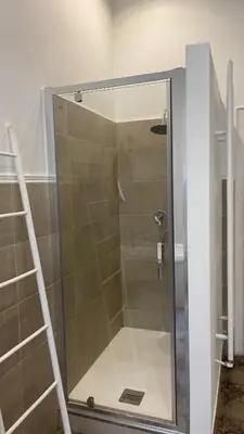 a shower with a glass door and a ladder at DonnaFrancaFlorio in Palermo
