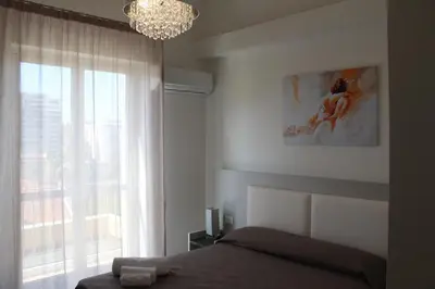 a bedroom with a bed and a window with a chandelier at Rahal B&B in Palermo