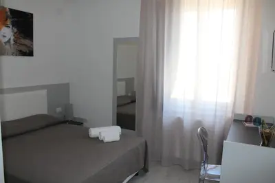 a small bedroom with a bed and a mirror at Rahal B&B in Palermo