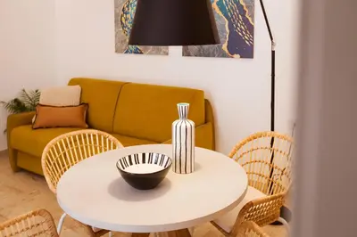 a living room with a table with chairs and a couch at NITI Palace in Castellammare del Golfo
