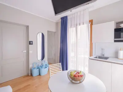 a white kitchen with a bowl of fruit on a table at NITI Palace in Castellammare del Golfo