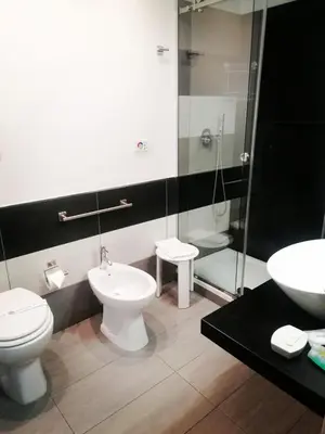a bathroom with two toilets and a shower and a sink at La Dimora del Massimo in Palermo