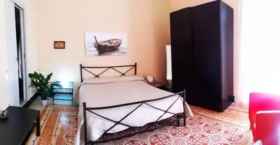 a bedroom with a bed and a black cabinet at La Dimora del Massimo in Palermo